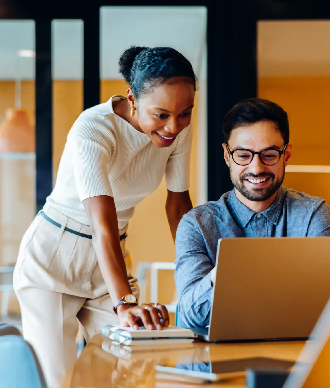 A benefits strategist reviewing a plan with a business owner at his laptop
