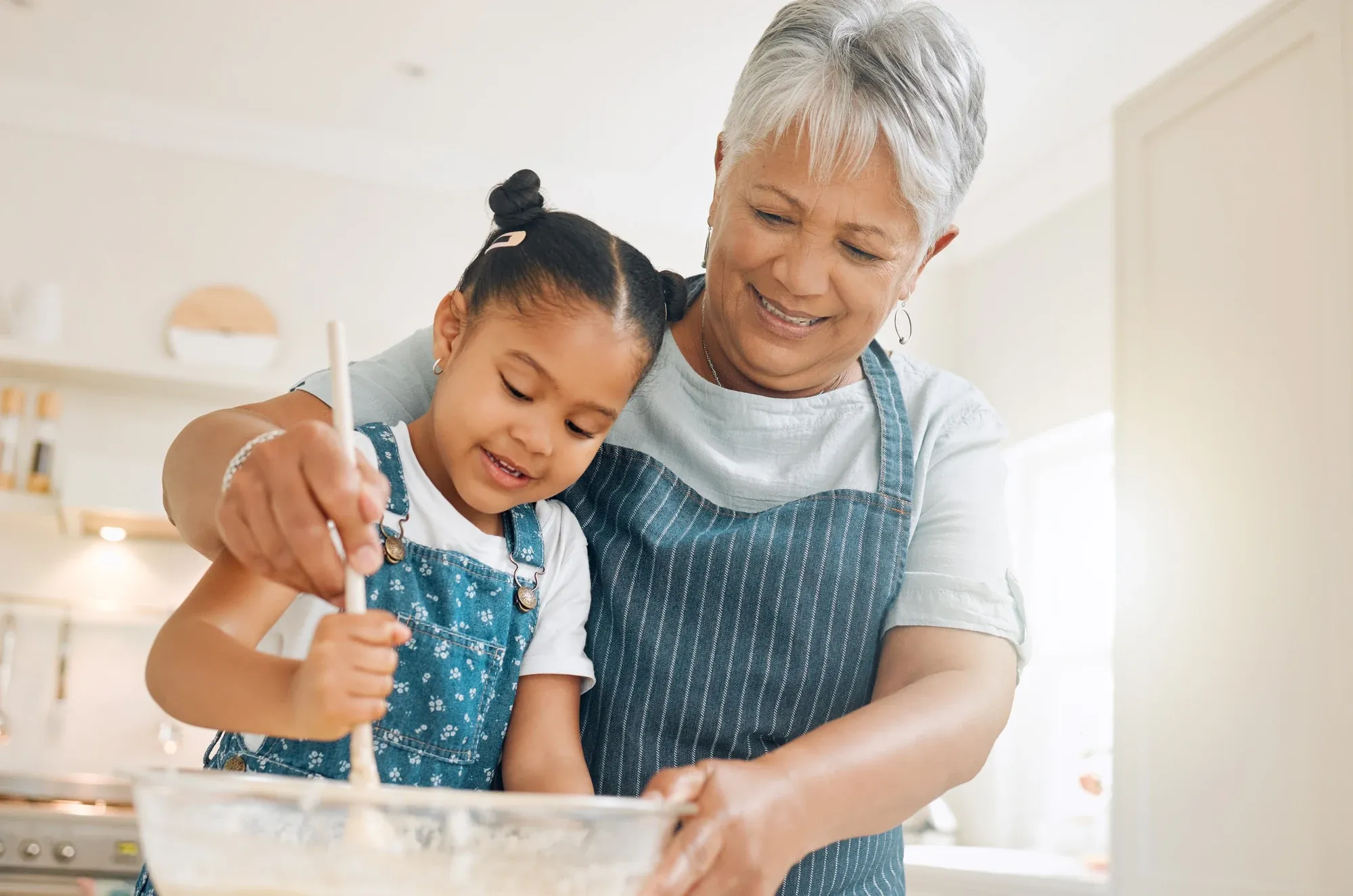 Grandmother baking in the kitchen with her young granddaughter