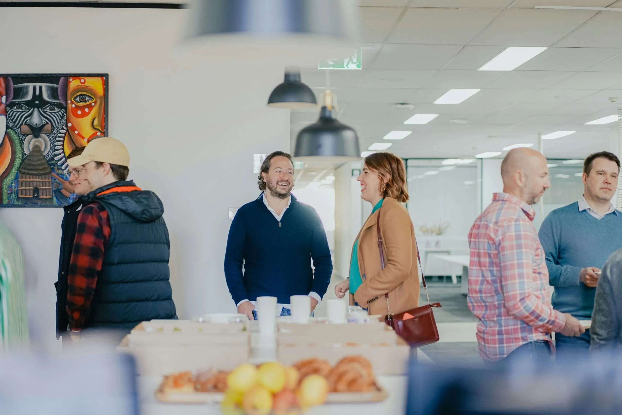 Employees gathered together over coffee in a bright, welcoming office